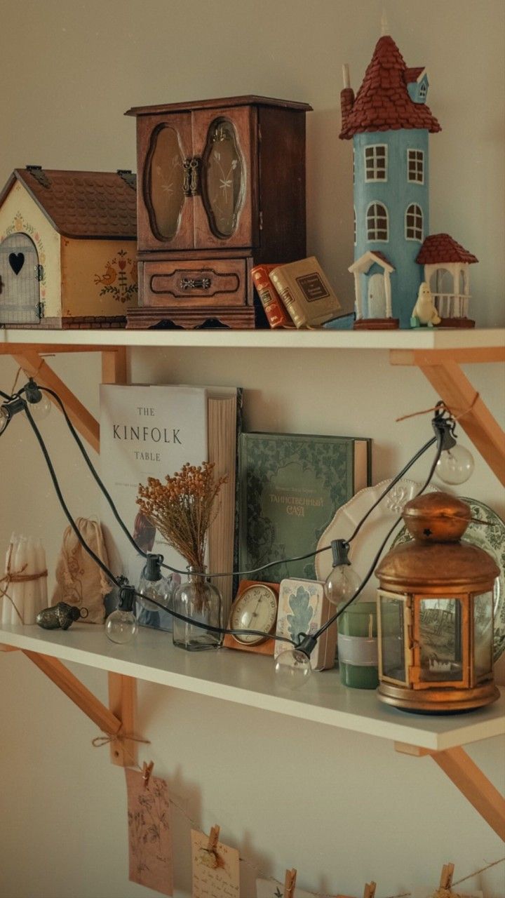 two shelves with books and miniature houses on them