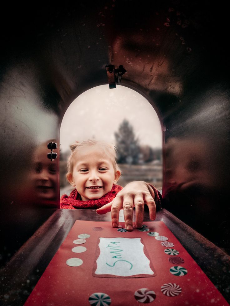 a young child is playing with a red table in the middle of a play area