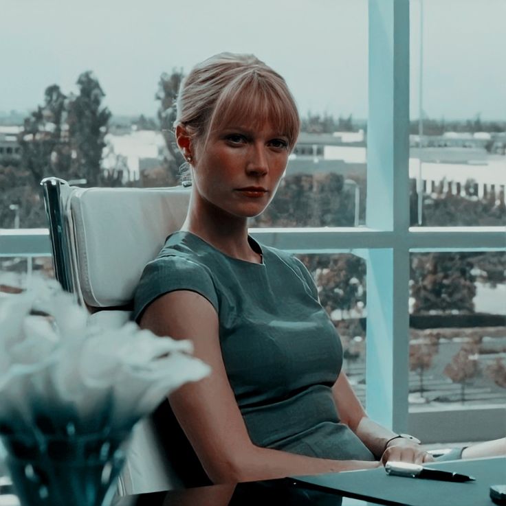 a woman sitting in a chair next to a window