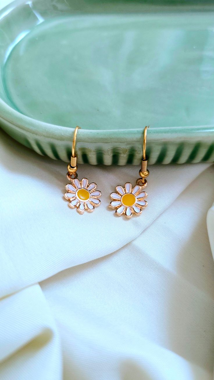 Add a touch of whimsy to your outfit with our Daisy Earrings. These adorable daisies will bring a smile to your face and brighten up any look. Perfect for adding a playful touch to your style. 🌼 Earring Details: White daisies Gold furnishings Fun White Earrings For Everyday, Whimsical Spring Flower Earrings With Ear Wire, Fun White Everyday Earrings, Daisy Shaped Earrings For Summer, Daisy-shaped Earrings For Summer, Daisy Flower Earrings For Spring, Whimsical Spring Earrings With Flower Charm, Spring Daisy Flower Earrings, Cute Adjustable Flower Earrings For Spring