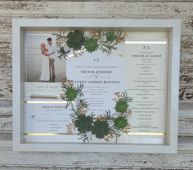 a wedding program with succulents and greenery is displayed in a white frame