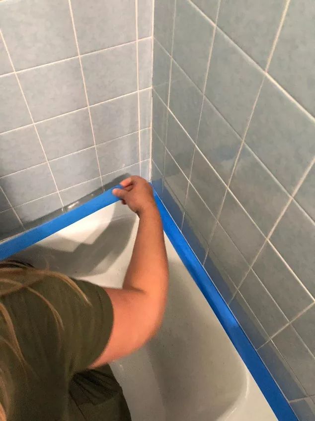 a person is in the bathtub with blue tape