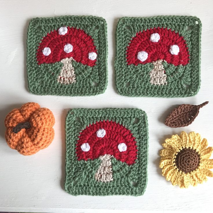 four crocheted coasters with mushrooms and sunflowers on the top one