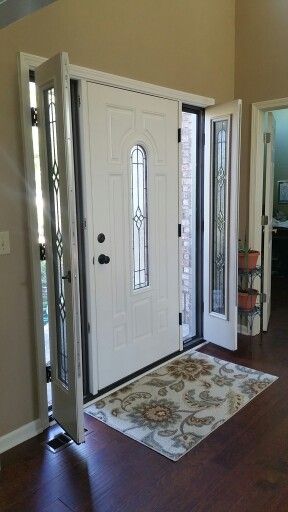 an entryway with two doors and a rug on the floor