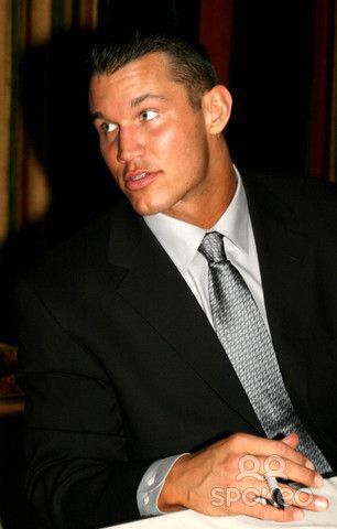 a man in a suit and tie sitting at a table with his hand on his lap