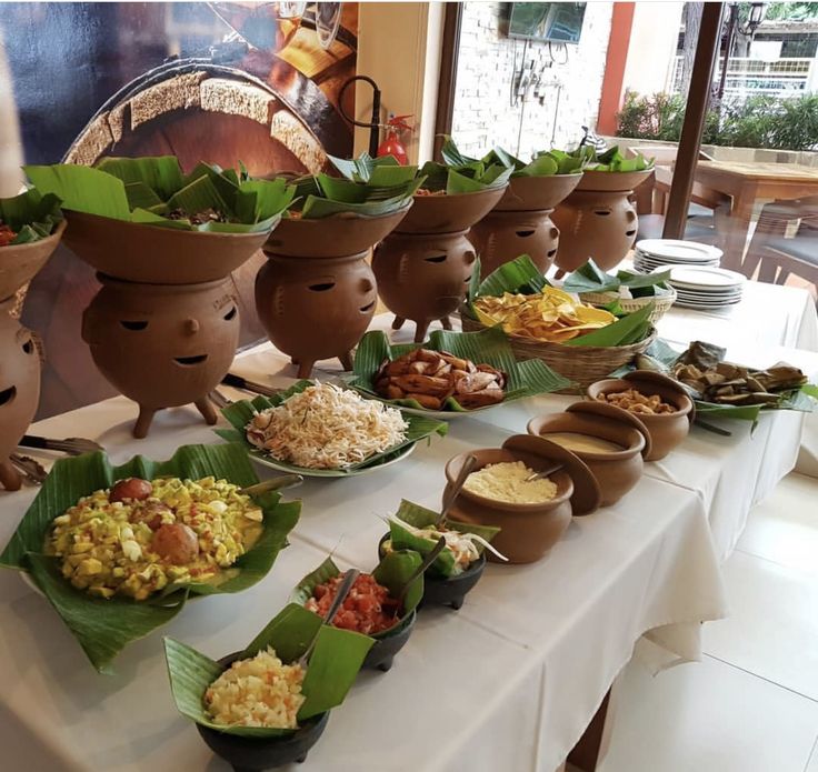 a table topped with lots of different types of food on top of plates and bowls