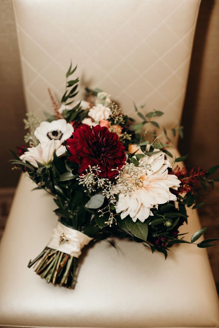 a bouquet of flowers sitting on top of a white chair