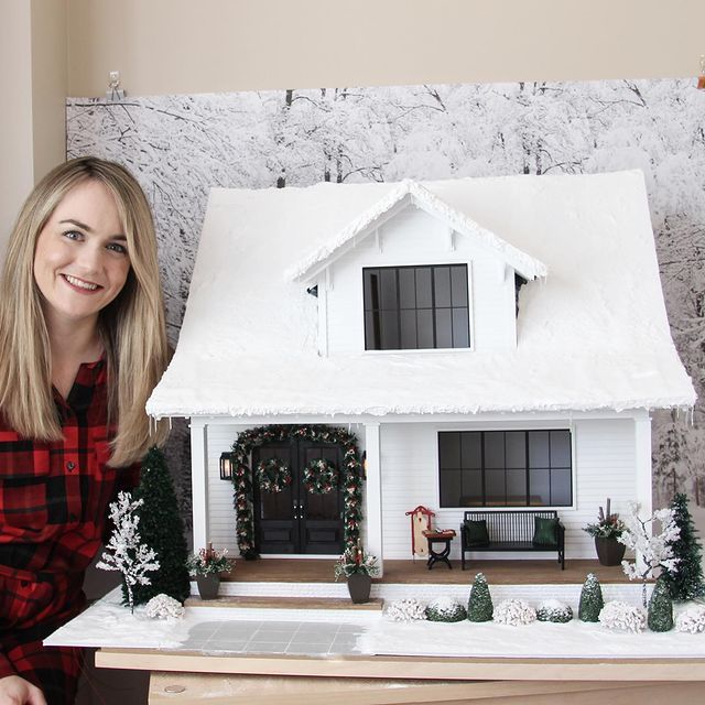 a woman standing in front of a model house