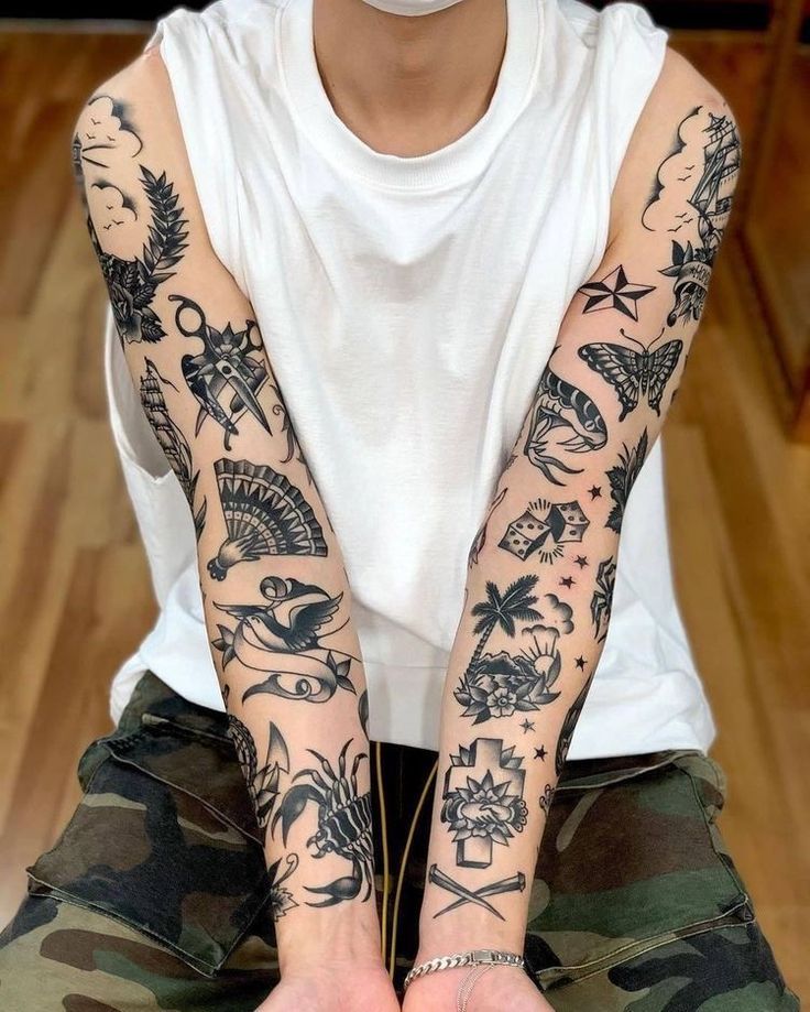 a person sitting on the floor with tattoos on their arms and hands, all over their body