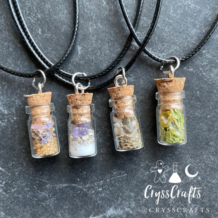 three glass bottles filled with different types of herbs on a black cord necklace, sitting next to each other