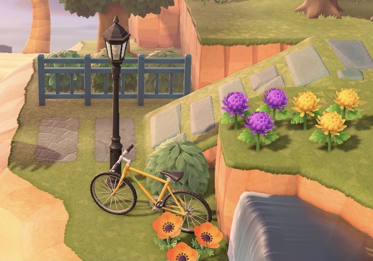 a bike parked next to a lamp post near flowers and a bench on the side of a cliff