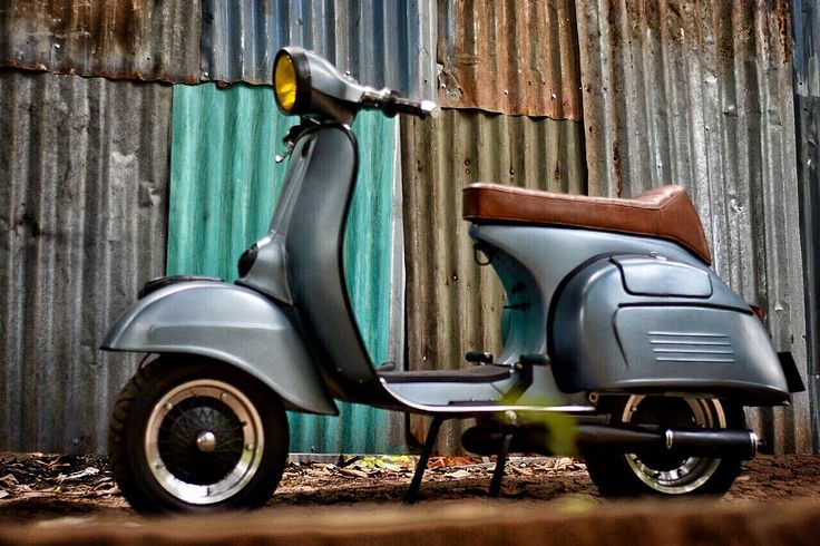 a scooter parked in front of a corrugated wall