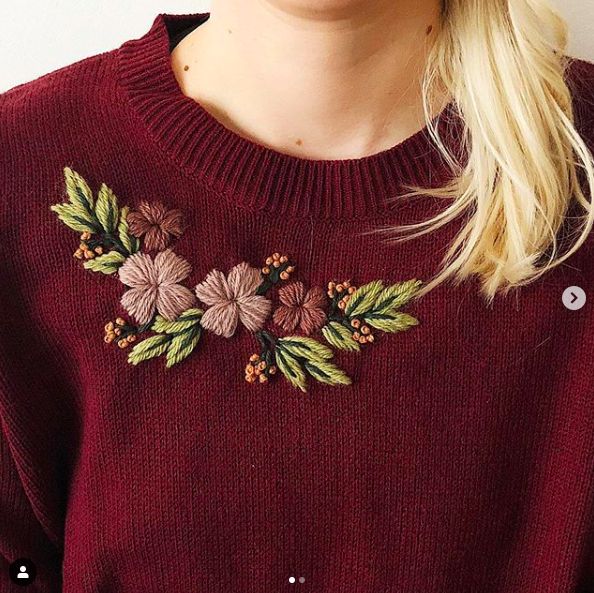 a woman wearing a red sweater with flowers on it