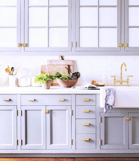 a kitchen with gray cabinets and gold handles