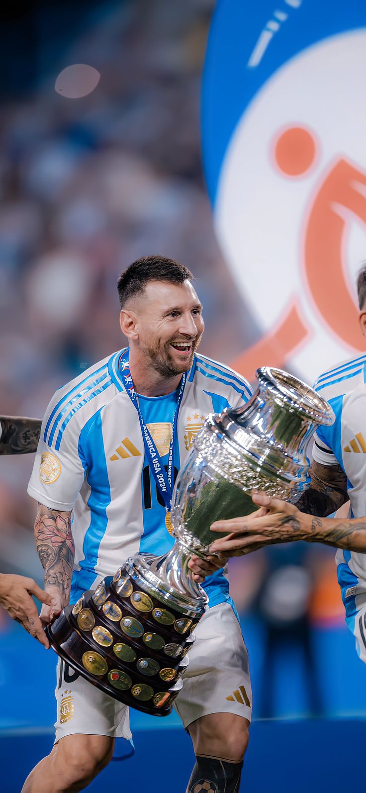 two soccer players are holding the trophy and smiling at each other while they hold it in their hands