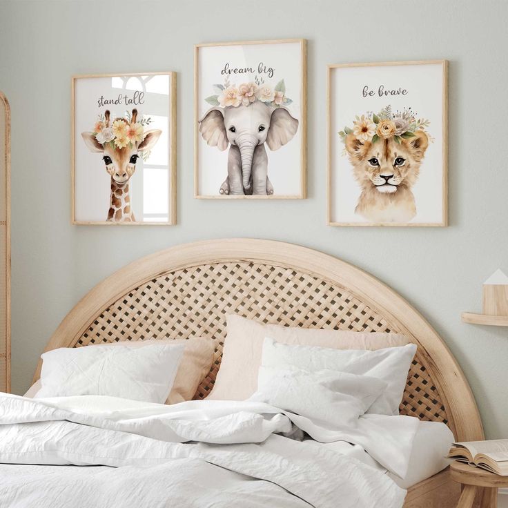 a bed in a bedroom with three pictures on the wall above it and an animal head