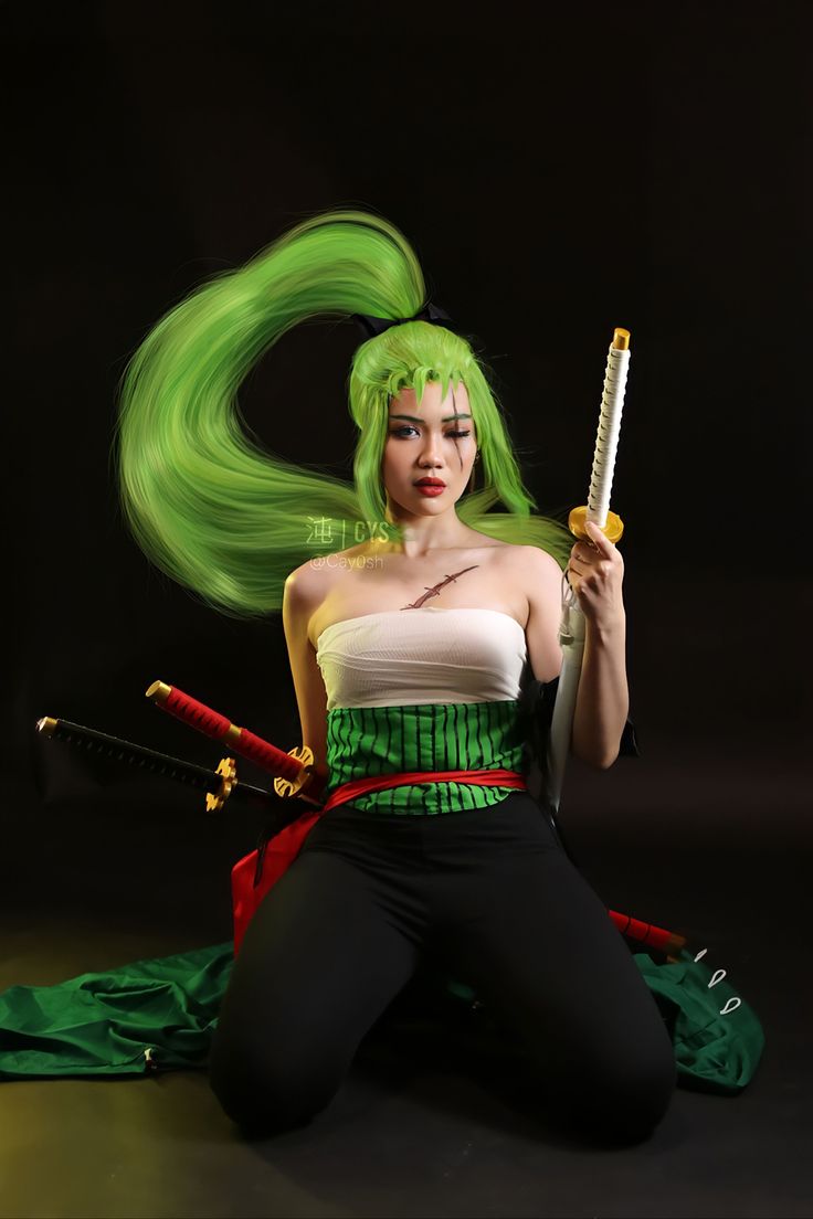 a woman with green hair is sitting on the floor and holding two swords in her hands