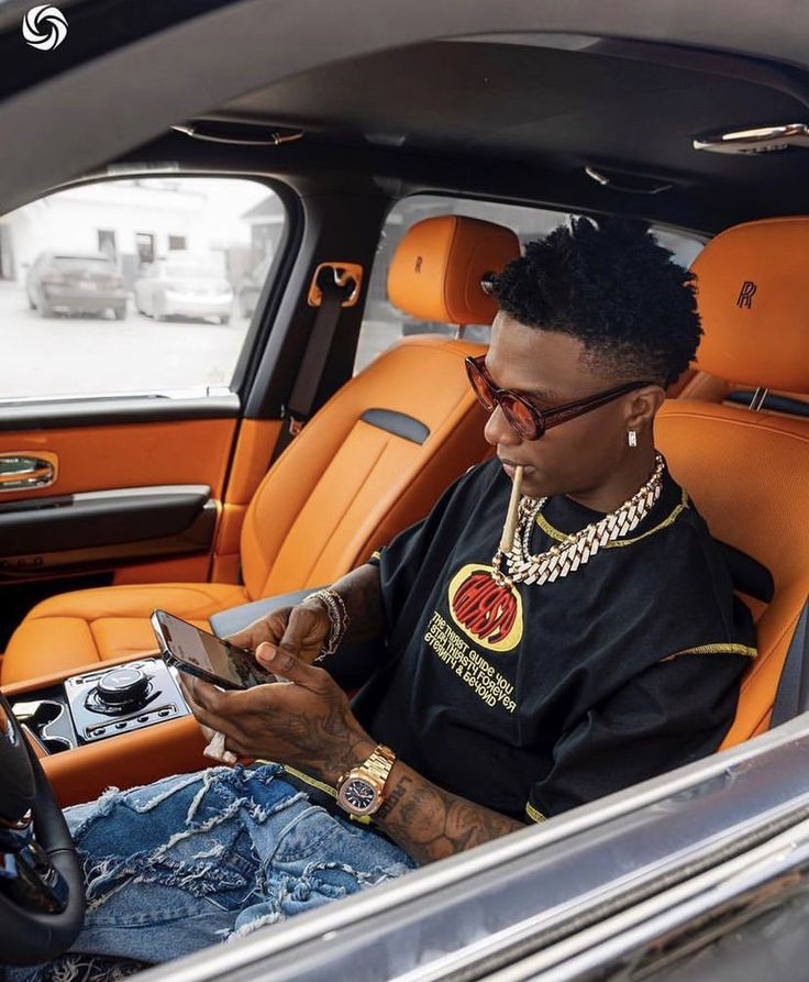 a man sitting in the back seat of a car looking at his cell phone