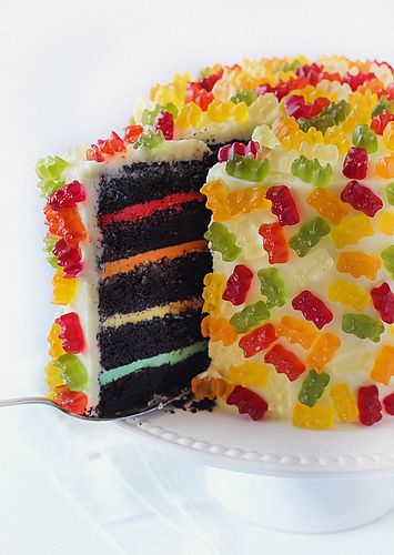 a cake with gummy bears on it and a slice missing