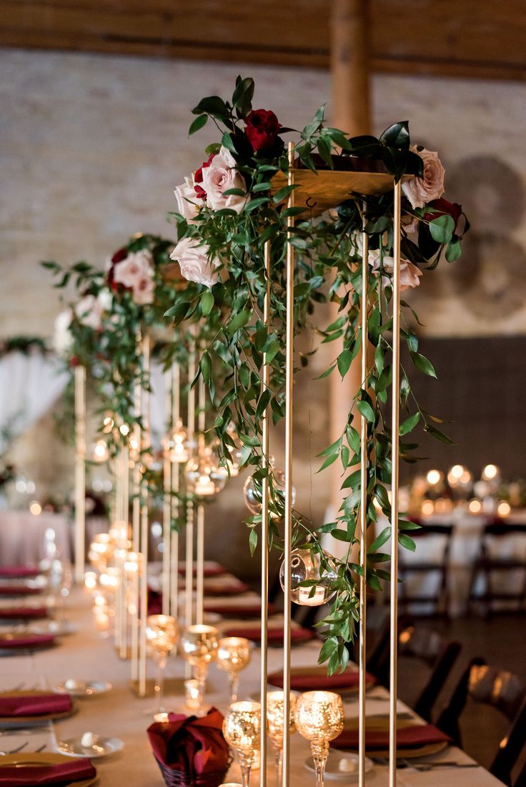 the table is set with candles, flowers and greenery for an elegant wedding reception