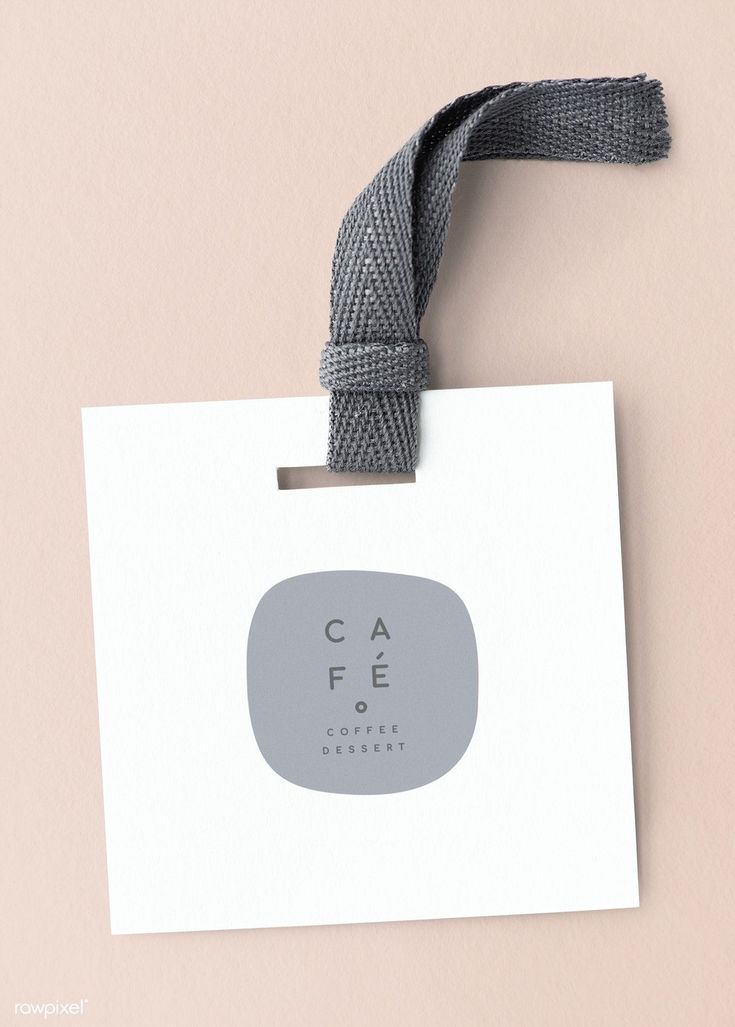 a white card with a gray ribbon hanging from it's side on a pink background