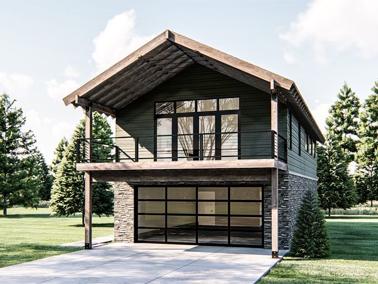 a two story house with an attached garage in the middle of a grassy area next to trees