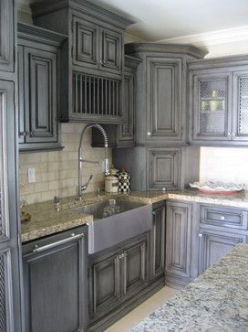 a kitchen with gray cabinets and marble counter tops