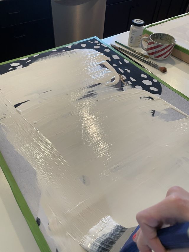 someone is painting on the table with white paint