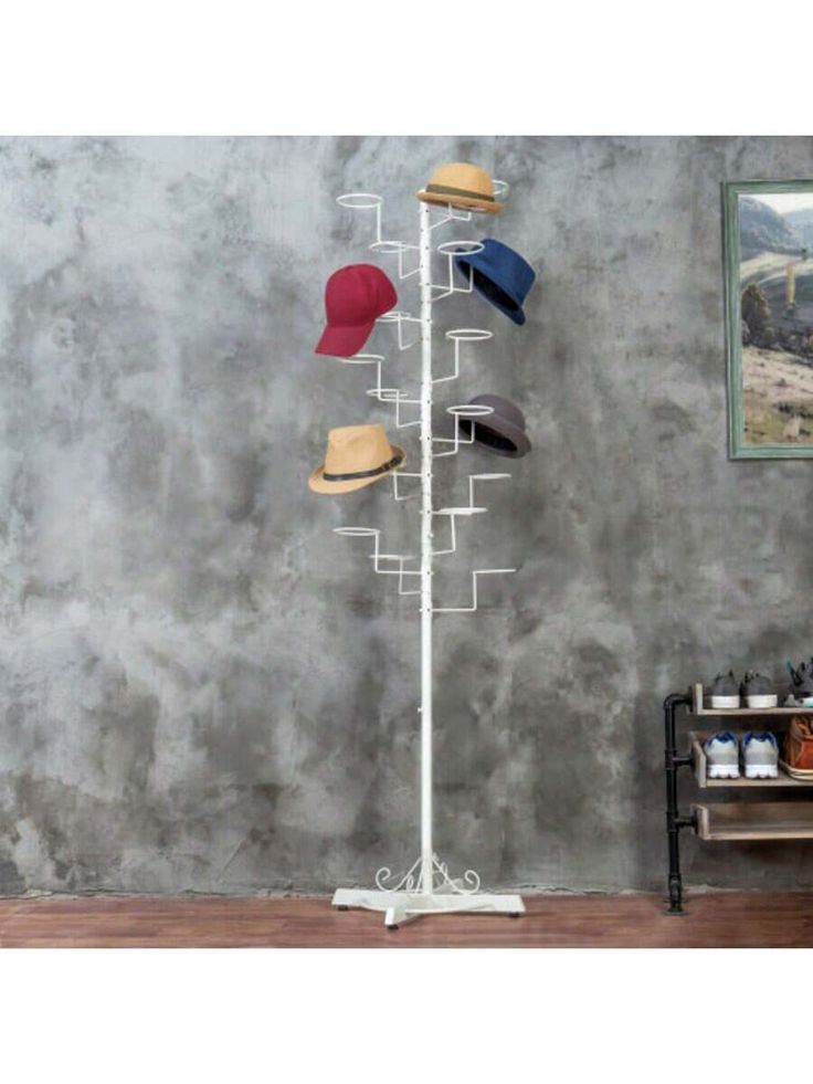 a hat rack with five hats on it in front of a wall and a bench