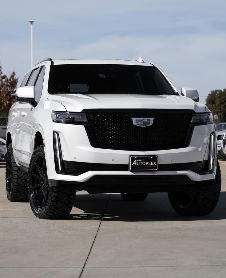 the front end of a white suv parked in a parking lot