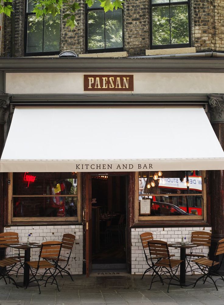 the outside of a restaurant with tables and chairs