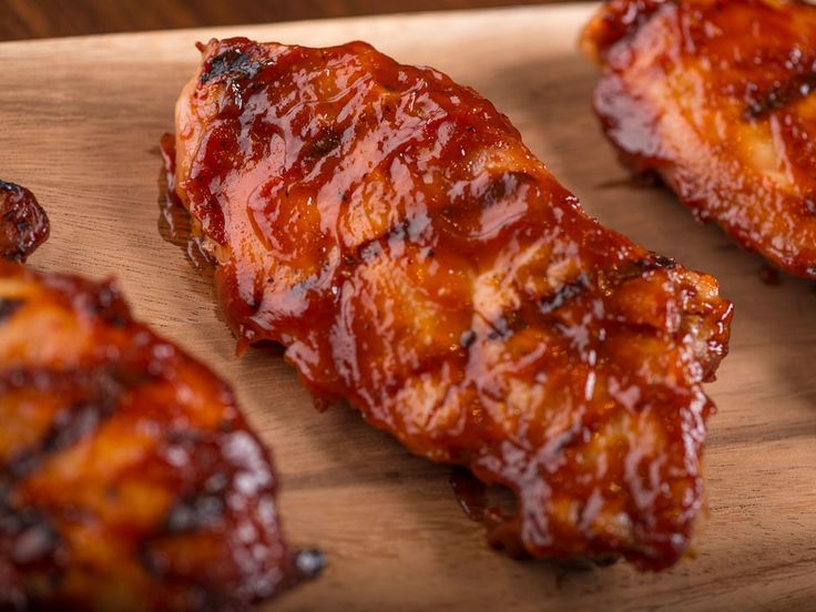 bbq chicken wings on a cutting board with ketchup