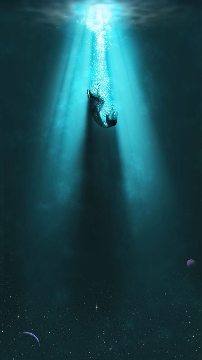 a person swimming in the water with their head above the surface and light shining on them