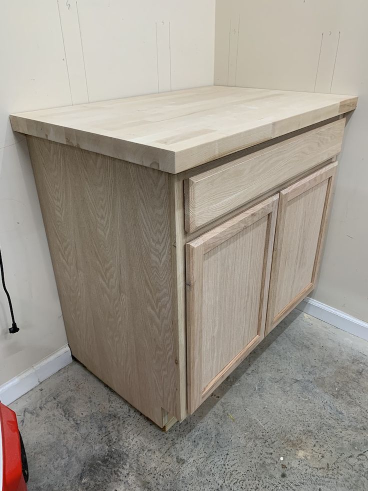 a wooden cabinet sitting on top of a cement floor