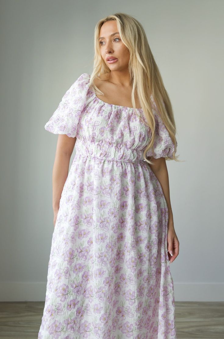 Expertly crafted for style and comfort, our Blossom Floral Print Midi Dress in Lavender is perfect for any occasion. Featuring charming puff sleeves, a flattering elastic waist, and convenient pockets, this dress effortlessly combines classic elegance with modern functionality. The square neck adds a touch of sophistication, making it a must-have for any wardrobe. square neckline puff sleeves elastic waist lined 100% polyester true to size model is wearing a medium Lavender Floral Print Short Sleeve Dress, Purple Midi Dress With Smocked Bodice, Feminine Lavender Floral Print Midi Dress, Lavender Short Sleeve Midi Dress For Spring, Spring Lavender Short Sleeve Midi Dress, Feminine Lavender Midi Dress With Floral Print, Feminine Lavender Midi Dress For Garden Party, Feminine Purple Short Sleeve Midi Dress, Feminine Purple Puff Sleeve Mini Dress