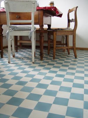 two wooden chairs sitting next to each other on top of a checkerboard floor