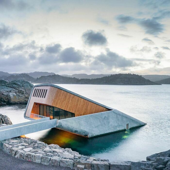 an unusual house built into the side of a body of water