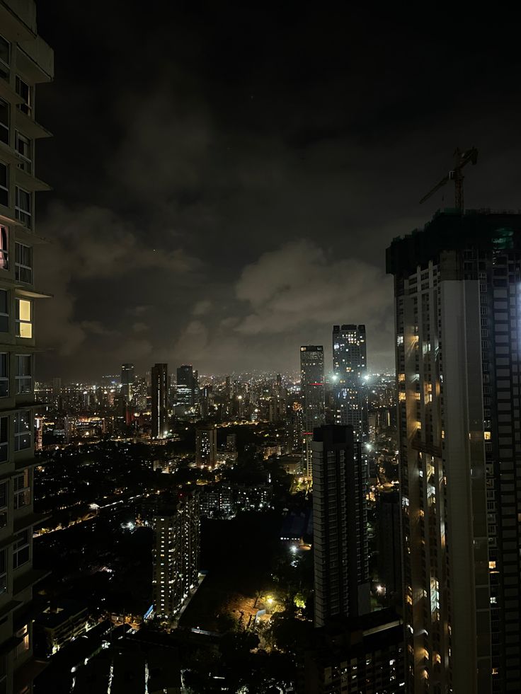 the city lights shine brightly at night from high up in the sky above skyscrapers