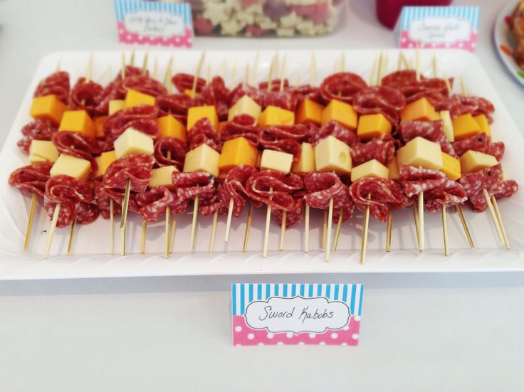 meat and cheese skewers are displayed on a platter