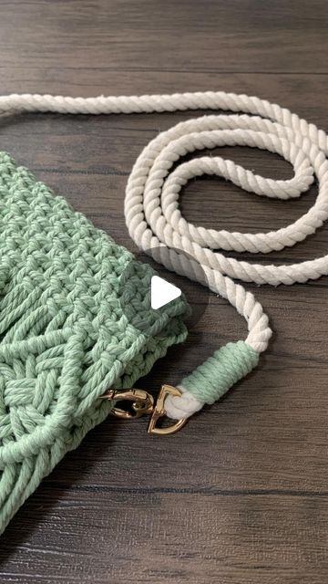 a green and white blanket laying on top of a wooden floor next to a cord