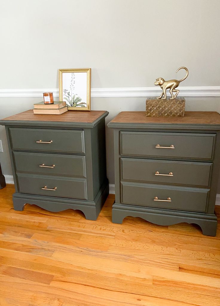 two green nightstands sitting on top of a hard wood floor next to a white wall