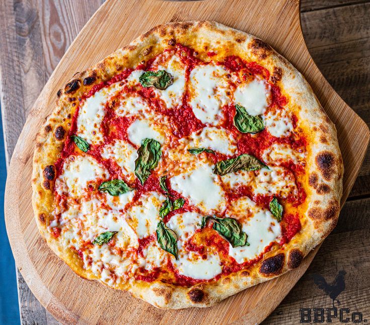 a pizza sitting on top of a wooden cutting board