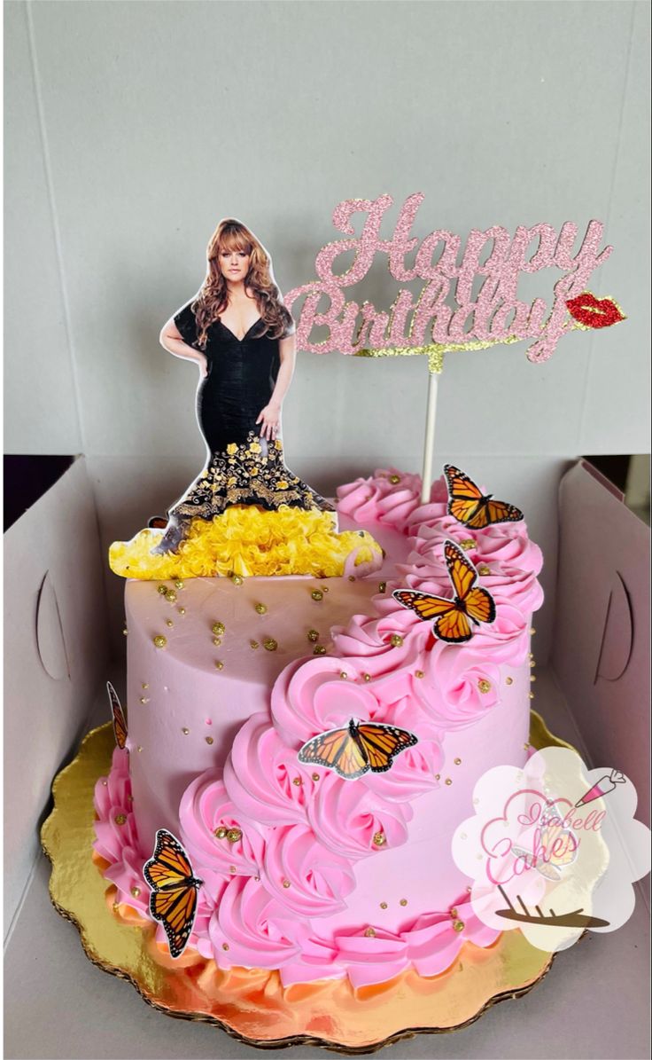 a pink birthday cake decorated with butterflies and a woman on top is in a box