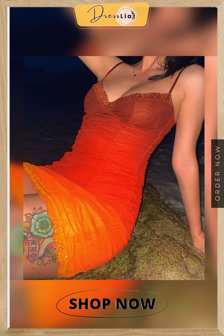 a woman in an orange dress sitting on a rock with her arm around the waist