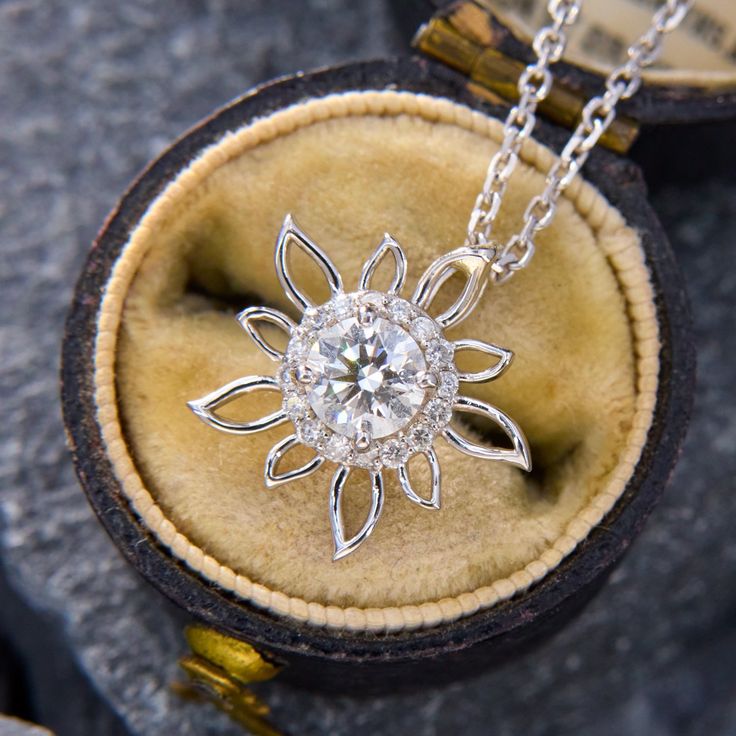 This sweet floral pendant is centered with one (1) round brilliant cut diamond, weighing 0.50 carats, set in four prongs. The diamond is surrounded by a halo of sixteen (16) round brilliant cut diamonds in shared prong settings. The pendant measures 15.0mm wide by 4.0mm thick and is signed JD & CO. The pendant hangs from a 1.3mm wide diamond cut adjustable cable chain that is 18 inches long and can be worn at 16 or 17 inches.  The chain is finished with a lobster clasp. Exquisite Diamond Flower-shaped Jewelry, Exquisite Diamond Flower Pendant Jewelry, Diamond Necklace With Center Stone As A Gift, Diamond Necklace With Halo Setting, Brilliant Cut Flower Pendant Jewelry, Diamond White Flower-shaped Diamond Jewelry, Exquisite Diamond Jewelry With Flower Shape, Diamond White Diamond Flower-shaped Jewelry, Anniversary Lab Grown Diamond Necklace With Halo Setting