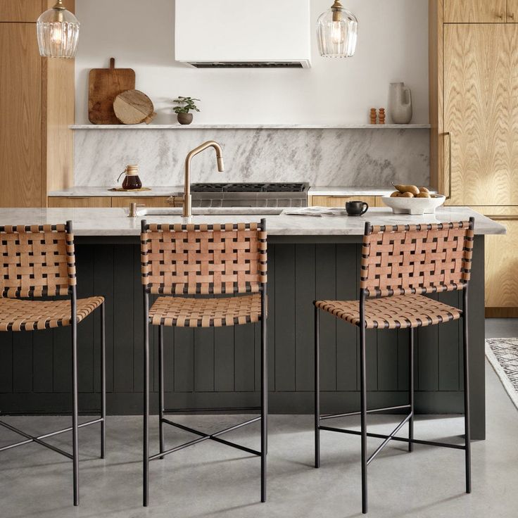 three chairs sitting in front of a kitchen island