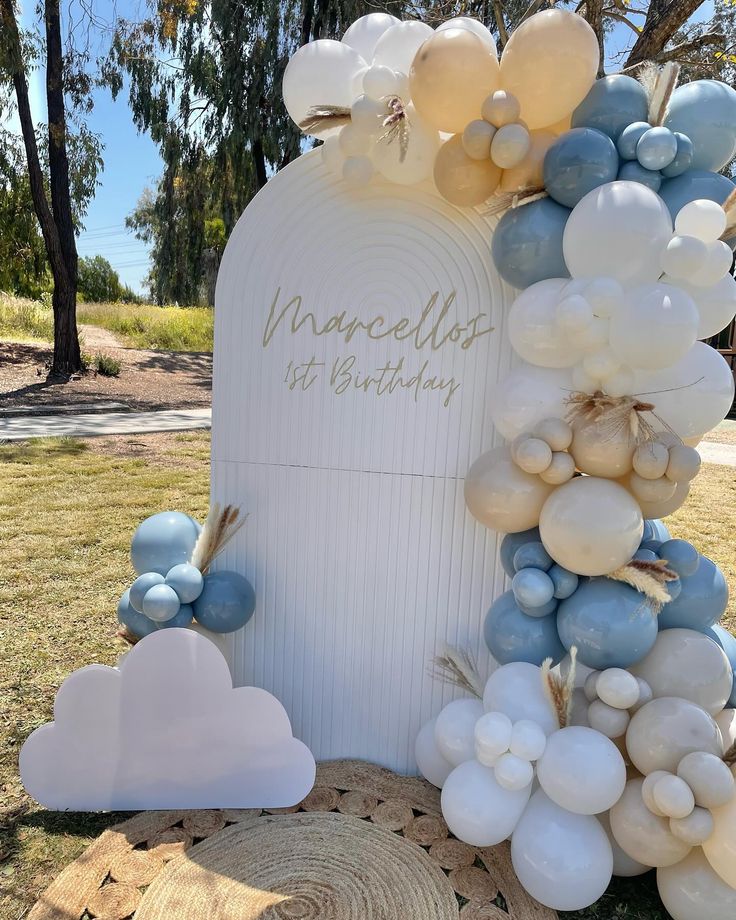 balloons and streamers decorate the top of a grave for someone's first birthday