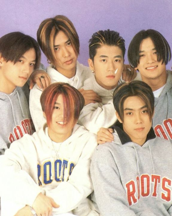 the group of young men are posing together for a photo in front of a purple background