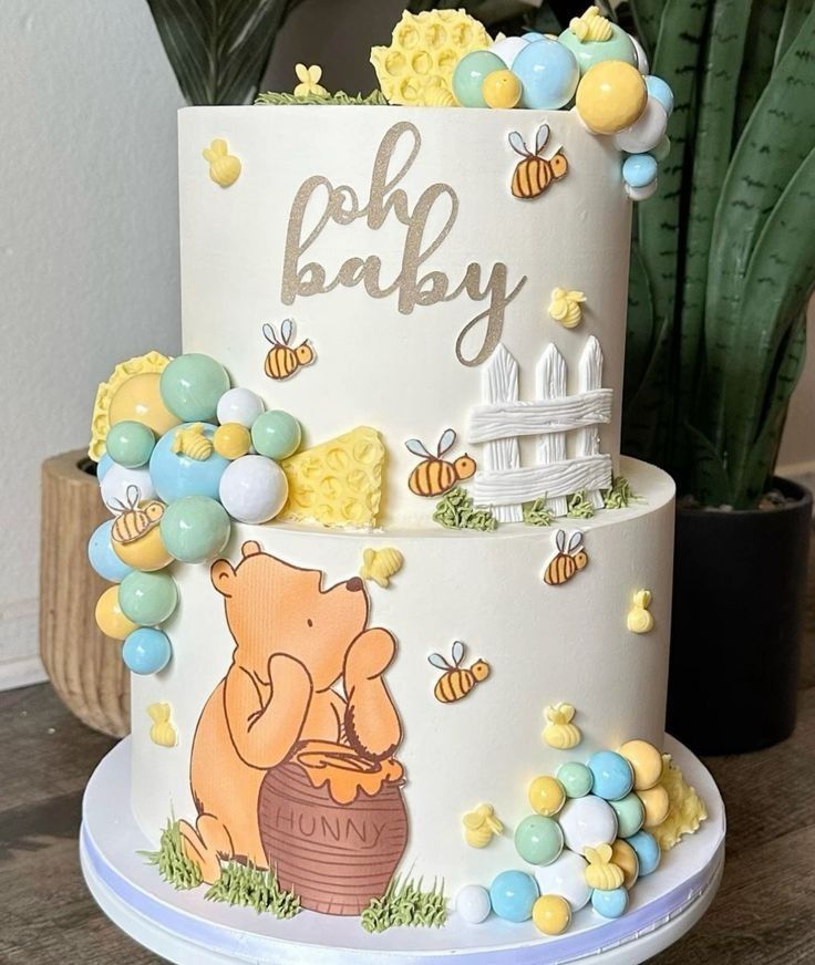 a winnie the pooh birthday cake is decorated with balloons and honeycombs on top