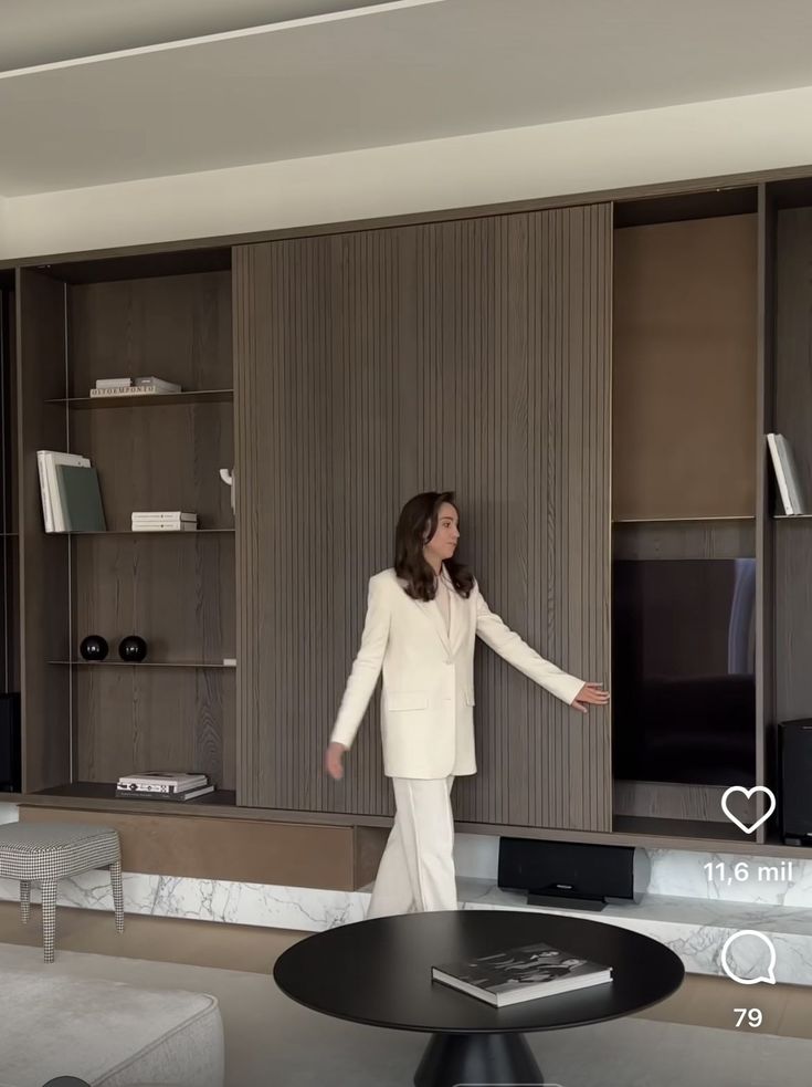 a woman standing in front of a tv next to a wall mounted flat screen television